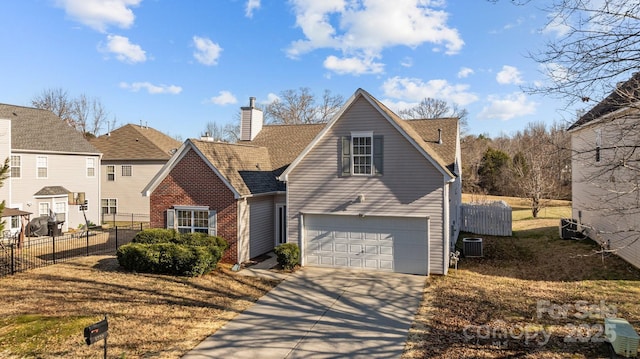 traditional-style home with brick siding, a chimney, concrete driveway, an attached garage, and fence