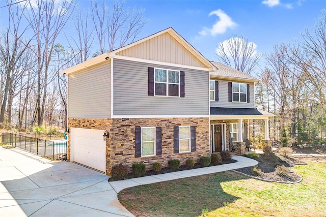 craftsman house featuring stone siding, fence, concrete driveway, and a front yard