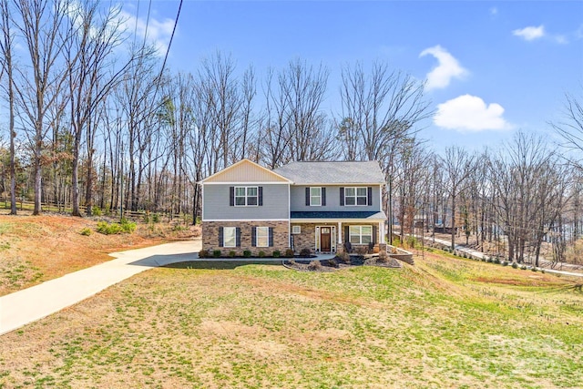 view of front of house with stone siding and a front yard