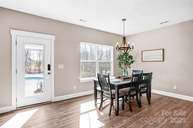 dining room featuring wood finished floors, visible vents, and baseboards