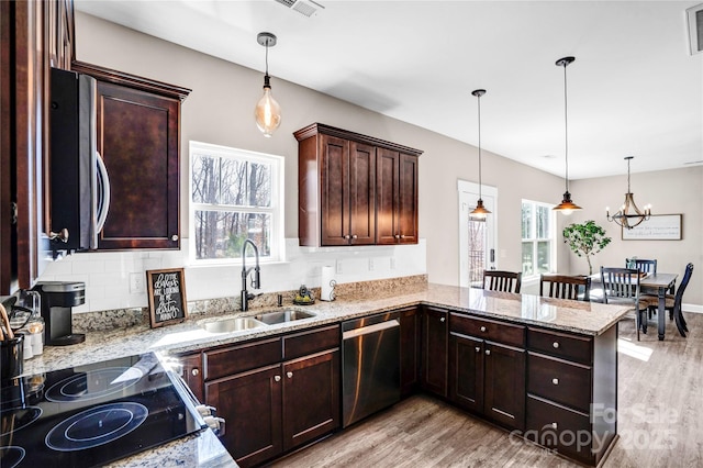 kitchen with dark brown cabinetry, a sink, stainless steel dishwasher, light stone countertops, and light wood finished floors