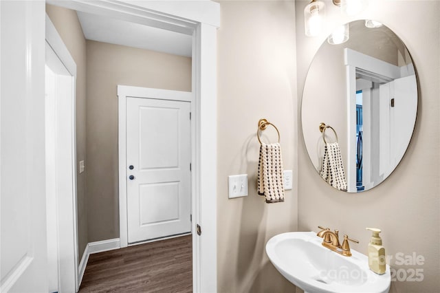 bathroom featuring wood finished floors, a sink, and baseboards