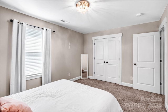 carpeted bedroom with a closet, visible vents, baseboards, and multiple windows