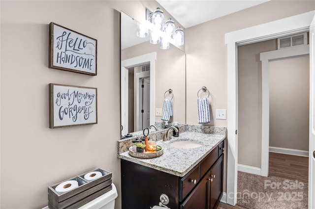 bathroom featuring visible vents, vanity, and baseboards