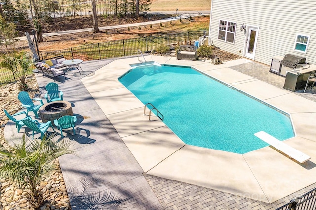 view of swimming pool featuring an outdoor fire pit, fence, a fenced in pool, and a patio