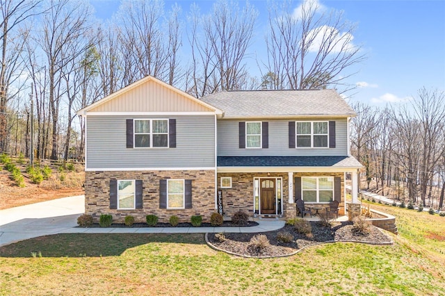 view of front of property with covered porch, stone siding, a front lawn, and concrete driveway