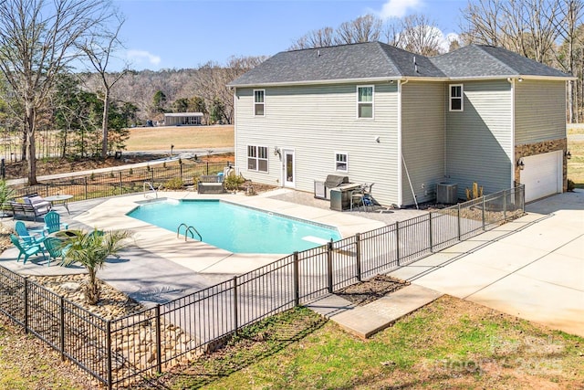 view of pool with a fenced in pool, a patio area, fence, and central AC