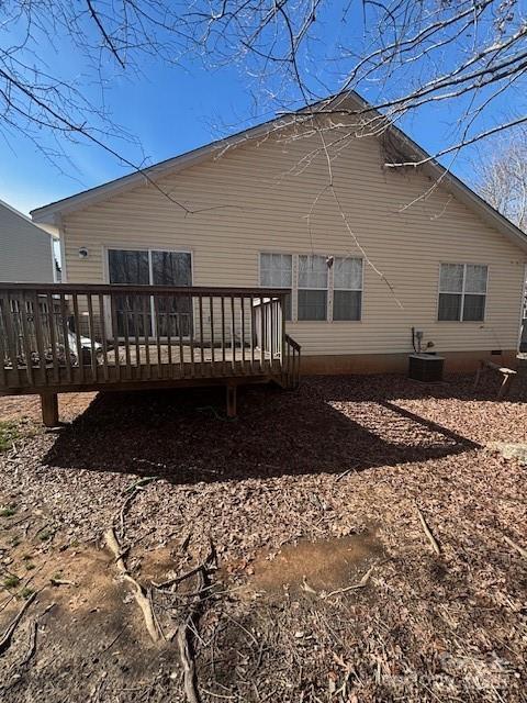 rear view of property with cooling unit and a wooden deck