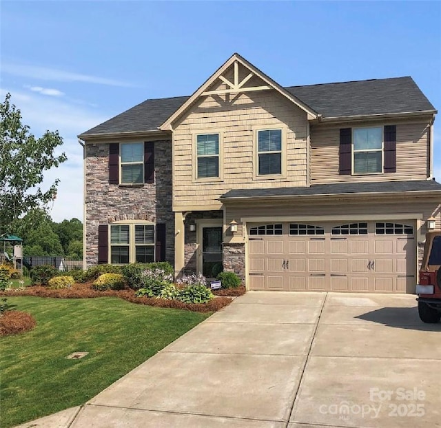 craftsman house with driveway, stone siding, an attached garage, and a front lawn