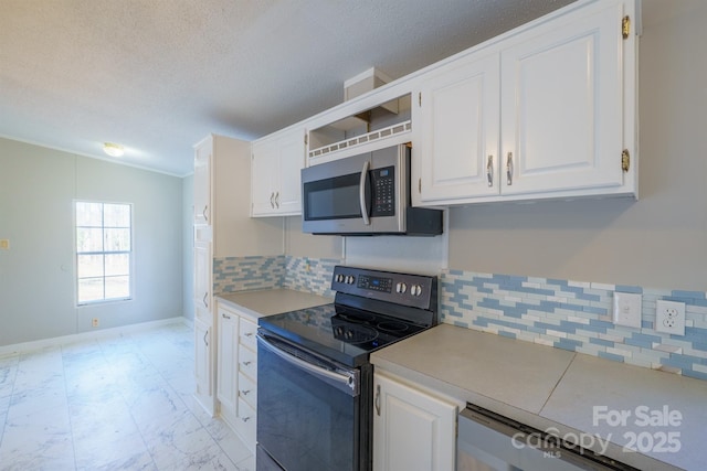 kitchen featuring backsplash, white cabinetry, a textured ceiling, stainless steel appliances, and ornamental molding