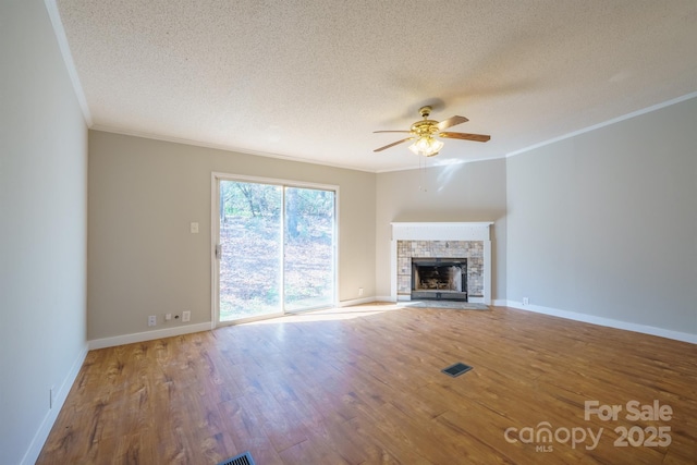 unfurnished living room with hardwood / wood-style flooring, ornamental molding, a textured ceiling, and ceiling fan