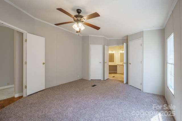 unfurnished bedroom with multiple windows, crown molding, and light colored carpet