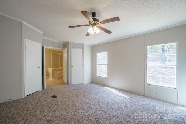 unfurnished room with ceiling fan, crown molding, carpet floors, and a textured ceiling