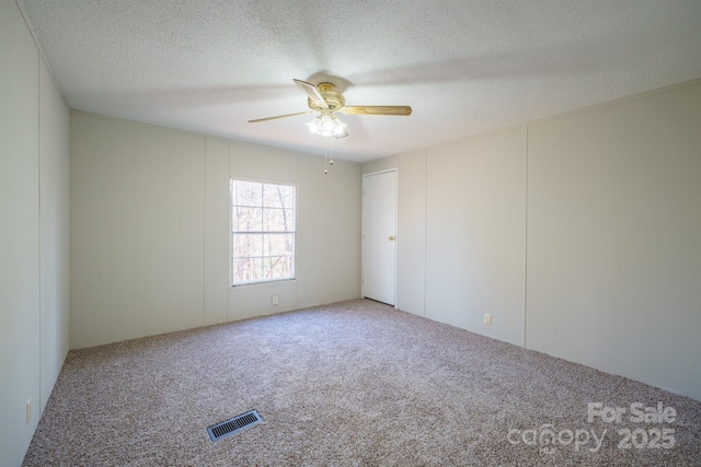 spare room with ceiling fan, carpet floors, and a textured ceiling