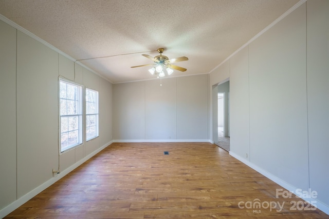 spare room with wood-type flooring, ceiling fan, crown molding, and a textured ceiling