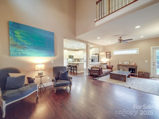 living area with recessed lighting, dark wood-type flooring, a ceiling fan, baseboards, and ornate columns