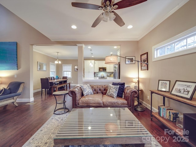 living room featuring dark wood finished floors, crown molding, and baseboards