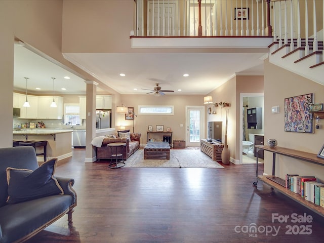 living area with baseboards, ceiling fan, recessed lighting, a high ceiling, and dark wood-style flooring