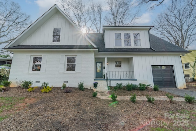 modern farmhouse style home featuring a garage, crawl space, a porch, board and batten siding, and brick siding