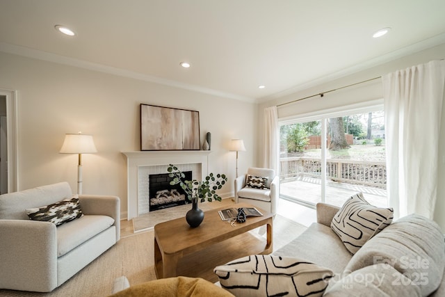 living room featuring light wood-style flooring, recessed lighting, a fireplace, baseboards, and crown molding