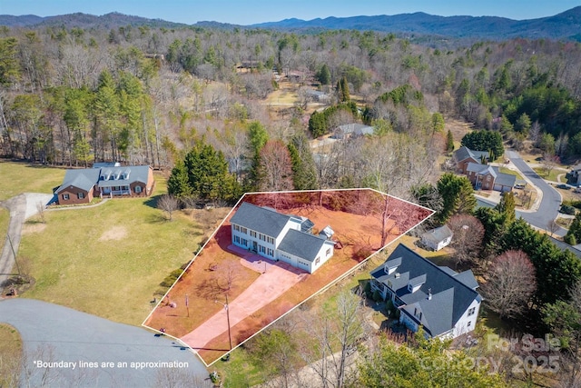 drone / aerial view featuring a forest view and a mountain view