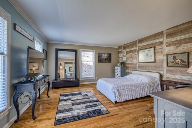 bedroom with baseboards, wood finished floors, and ornamental molding