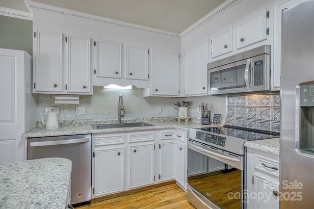 kitchen featuring white cabinets, appliances with stainless steel finishes, and a sink