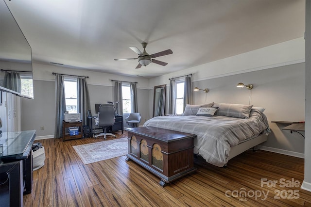 bedroom featuring a ceiling fan, baseboards, and wood finished floors