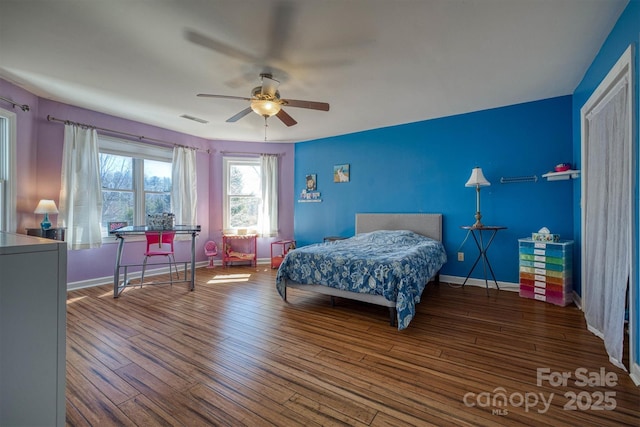 bedroom featuring visible vents, ceiling fan, baseboards, and wood finished floors