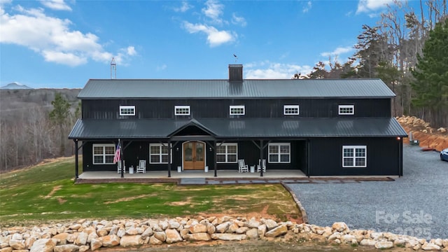 view of front of home featuring french doors, metal roof, and a front yard