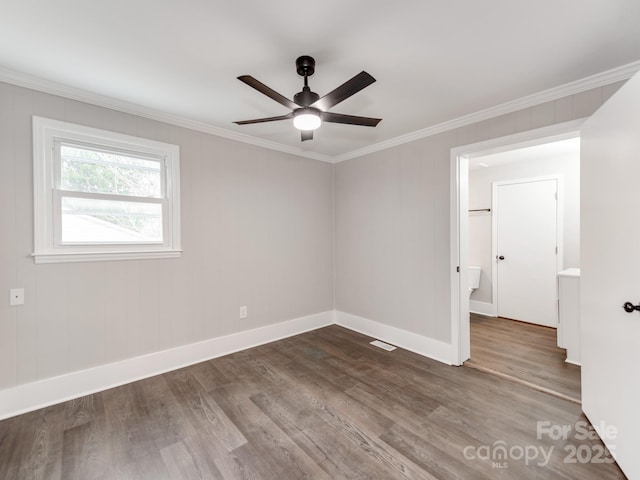 unfurnished room featuring ceiling fan, wood finished floors, visible vents, baseboards, and crown molding