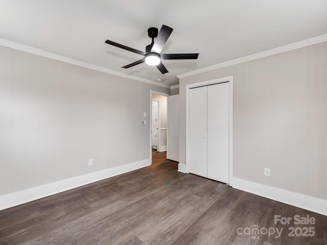 unfurnished bedroom featuring ceiling fan, wood finished floors, baseboards, ornamental molding, and a closet