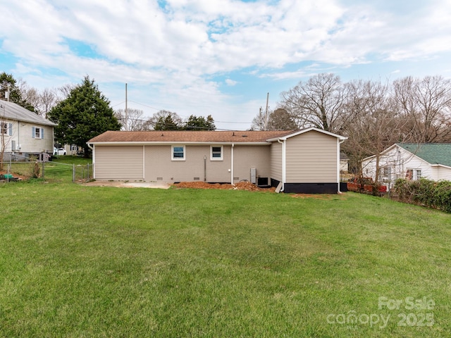 back of property with a yard, crawl space, and fence