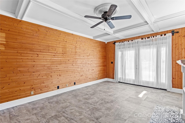 empty room with ceiling fan, wooden walls, coffered ceiling, ornamental molding, and beamed ceiling