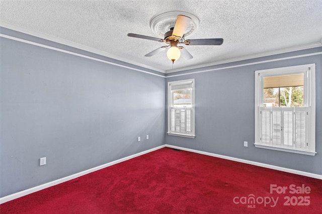 empty room with carpet floors, crown molding, a textured ceiling, and baseboards