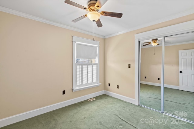 unfurnished bedroom featuring ornamental molding, a closet, carpet flooring, and baseboards