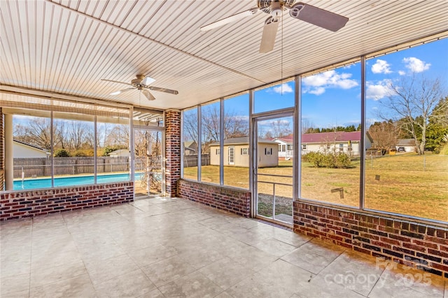 unfurnished sunroom with ceiling fan