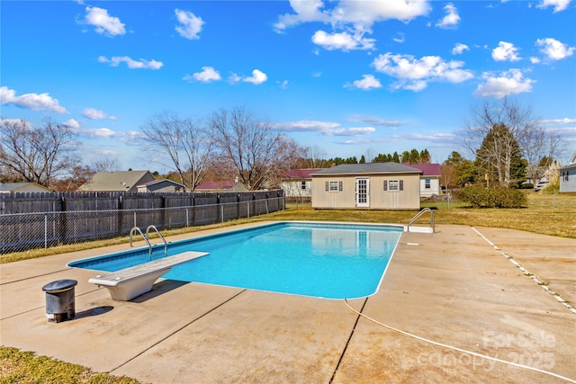 view of swimming pool featuring an outbuilding, a yard, a patio area, and a fenced backyard