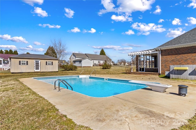 outdoor pool featuring an outbuilding, fence, a yard, a patio area, and an exterior structure