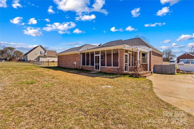 rear view of house featuring brick siding, fence, a sunroom, a yard, and a pergola