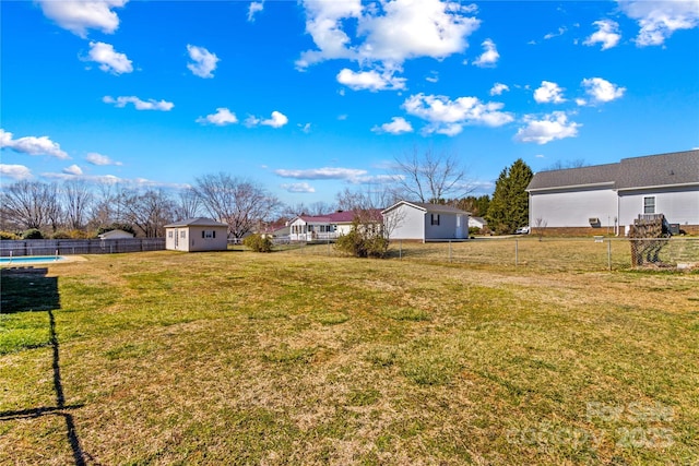 view of yard with an outbuilding, a fenced backyard, and a fenced in pool