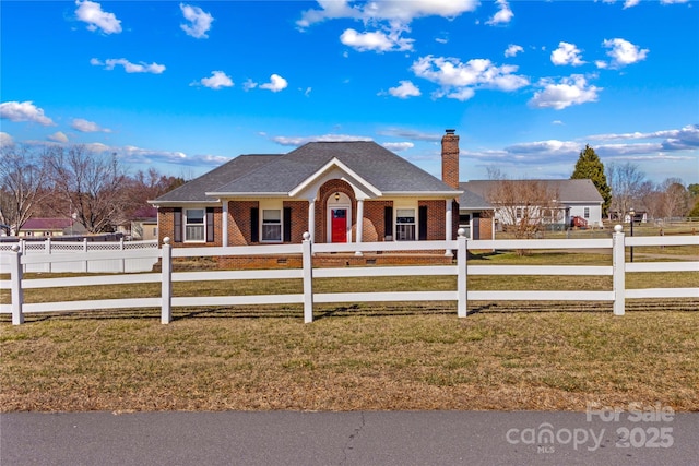 single story home featuring brick siding, a fenced front yard, a chimney, and a front yard