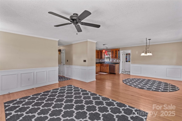 interior space with a textured ceiling, wood finished floors, and crown molding