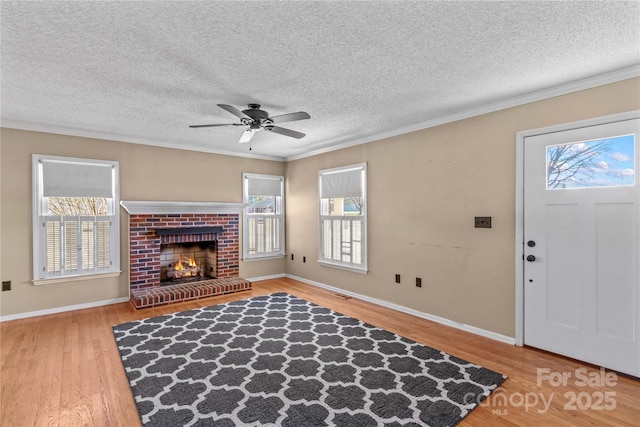 living area with a healthy amount of sunlight, a fireplace, and wood finished floors