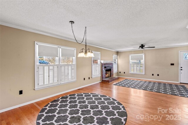 living room with ornamental molding, a fireplace, plenty of natural light, and wood finished floors