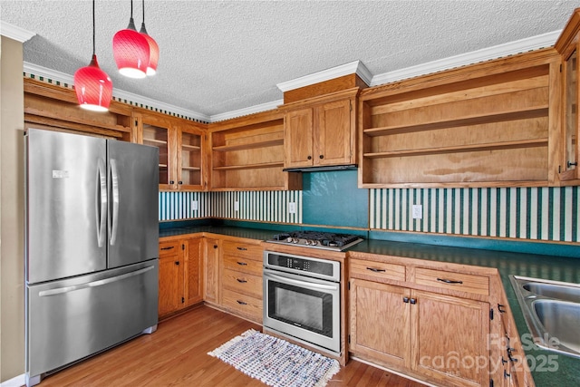 kitchen featuring appliances with stainless steel finishes, open shelves, a sink, and wood finished floors