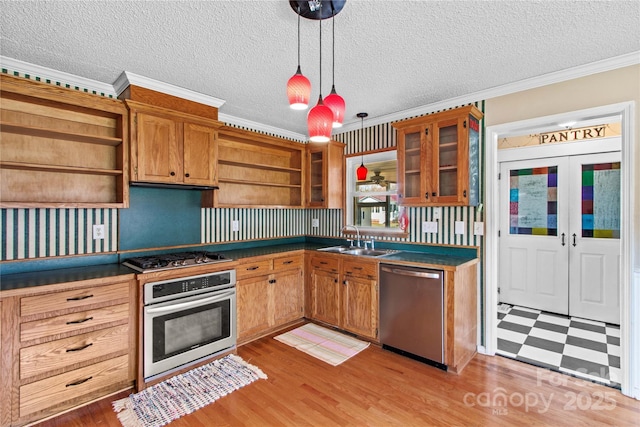 kitchen with open shelves, dark countertops, stainless steel appliances, and a sink