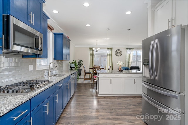 kitchen featuring dark wood-style floors, crown molding, blue cabinetry, appliances with stainless steel finishes, and a sink