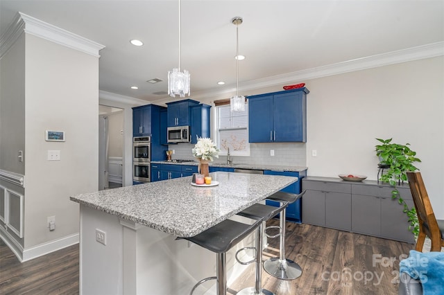 kitchen featuring appliances with stainless steel finishes, a kitchen breakfast bar, blue cabinets, crown molding, and backsplash