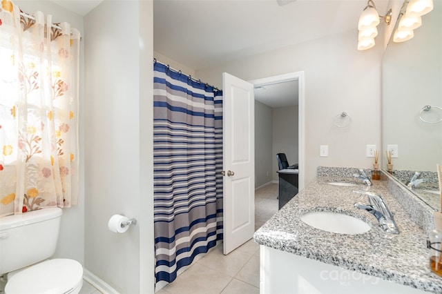 bathroom featuring double vanity, toilet, a sink, a chandelier, and tile patterned flooring